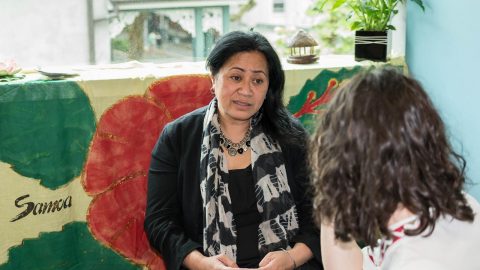 Woman sitting talking to another woman