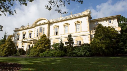 Beautiful picture of Old Government House with green lawn and cloudy blue sky on the background