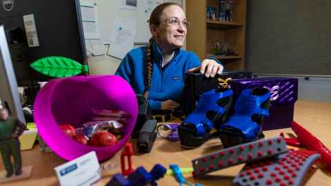 Eva in her office, with 3D models by her and students.