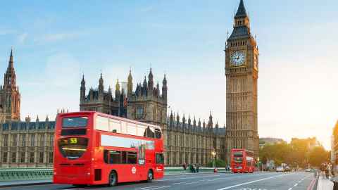 A traditional London bus is pictured outside the Houses of Parliament: UK Parliament takes back control from an executive seemingly willing to drive the country off the cliff of a No-deal Brexit, says Dr Neal Curtis.