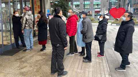 Shoppers wearing face masks are pictured lining up for temperature checks before entering a shopping mall in Chengdu, China. Photo: iStock