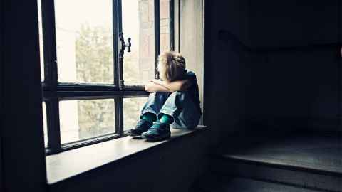 A small child sits alone on a window sill, his head down on his arms: "...a different system is required if we really want to make a difference to the well-being of children," says Ian Hyslop. Photo: iStock A small child sits alone on a window sill, his head down on his arms: "...a different system is required if we really want to make a difference to the well-being of children," says Ian Hyslop. Photo: iStock