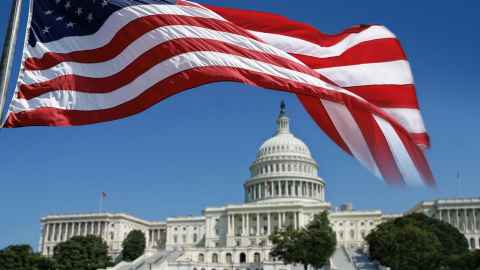 The image shows a US flag fluttering over The Capitol Building, a national symbol of the US and stormed by Trump supporters last week. Photo: iStock