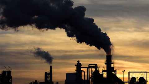 The image show chimneys belching our smoke against the sky of orange and grey: The Climate Change Commission notes "emissions must be reduced at pace while allowing the country to continue to grow". But emissions are the outcome of building an economy on cheap carbon. Photo: iStock