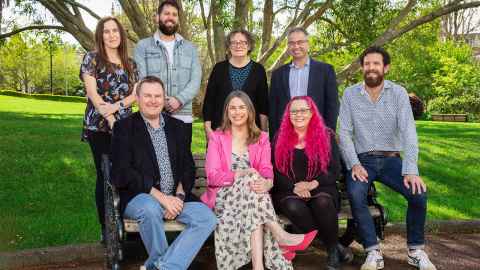 The image shows The modelling team when they were finally able to meet in person - they are sitting on and around a park bench. They are: Dr Emily Harvey, back left, Dr Oliver Maclaren, Associate Professor Ilze Ziedins, Andrew Sporle. From front left, Professor Shaun Hendy, Kate Hannah, Associate Professor Siouxsie Wiles, Dr Dion O'Neale. Photo: Billy Wong
