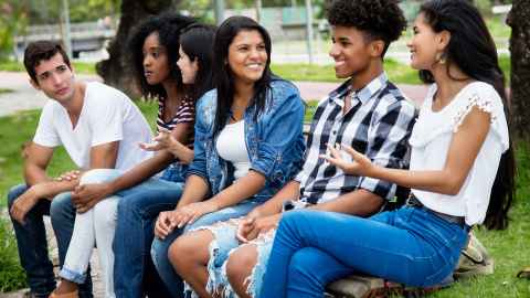 A group of young people of multi-ethnicities are pictured talking together: "If I am a skilled worker or student located overseas and I am looking to emigrate, will New Zealand be a priority for me?" This is the question asked by Professor Ananish Chaudhuri when he suggests dated thinking by the Government in the 2021 budget. Photo: iStock