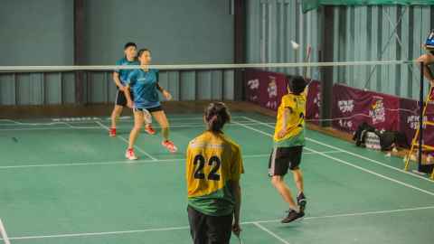 Woman badminton player lunging for the shuttlecock