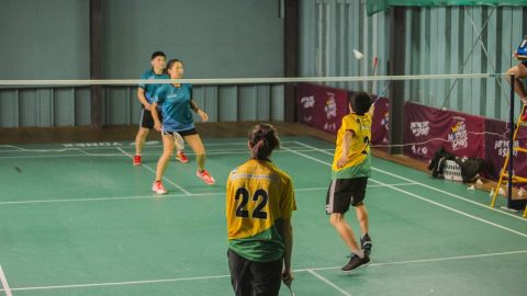 Woman badminton player lunging for the shuttlecock