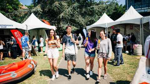 Students walking up a path with musical instrument case.
