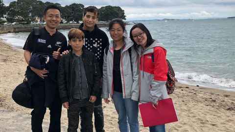 Group of students standing on a beach.