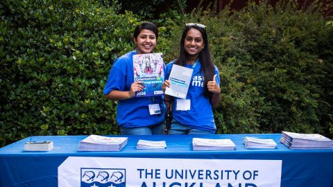 Two Student Ambassadors holding Orientation Programme brochures at Orientation.