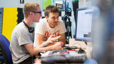 Two students collaborating at a computer.