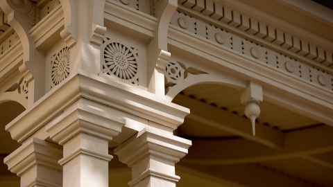 Close up of the corner of a building with a pillar with an intricate pattern