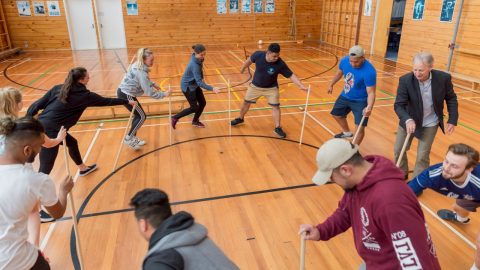 Sports students playing a stick game.