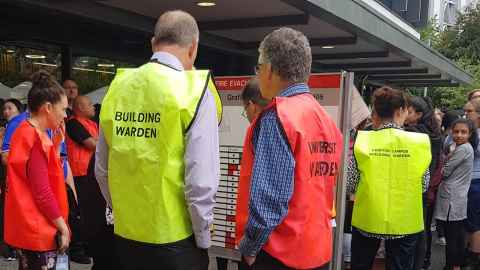 University wardens gather in an assembly area following an evacuation drill. 