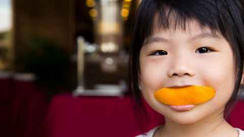 Toddler eating orange