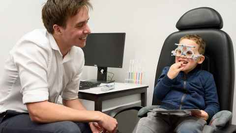 Optometry student Robert Burnie performs a vision test on a child.