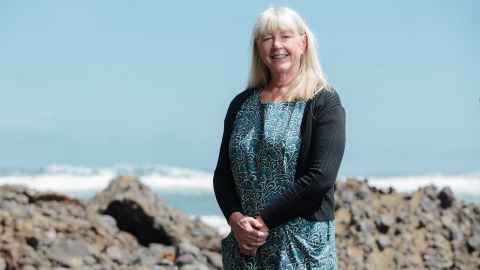 Dr Barbara Staniforth standing on the beach at Piha. 