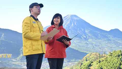 Pri Utami, right, with student Satria Widi in the Dieng volcanic complex, Central Java. The cone-shaped mountain is the Sundoro volcano.