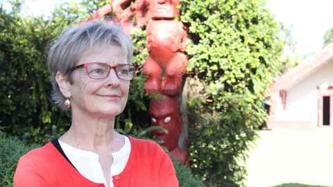 Dilys Johns standing outside Waipapa Marae at the University of Auckland.