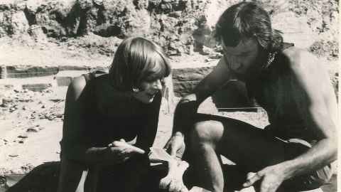 Dilys Johns and a colleague are crouching down looking at a moa butchery site in Central Otago in 1980.