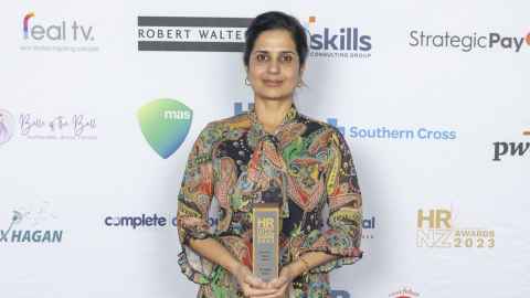 A photo of Deepika Jindal holding her Academic Impact Award