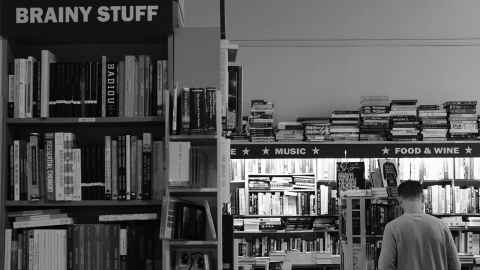 A man browsing the shelves inside Unity Books in Auckland