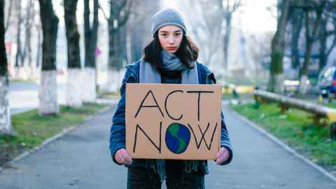 Climate change campaigner with sign that reads "act now"