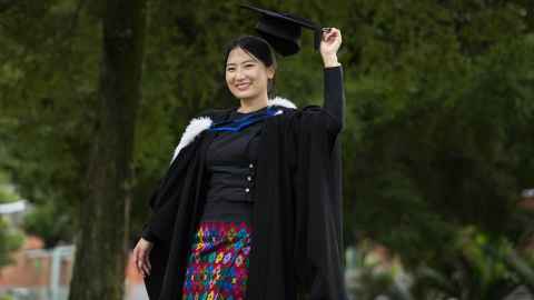 Ja in her graduation regalia, wearing a traditional Myanmar skirt