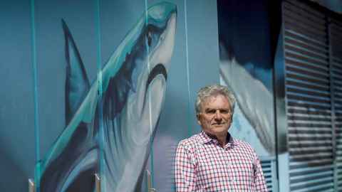 Emeritus Professor John Montgomery says modelling systems that feed into climate models can give a better sense of the connection between oceans and the atmosphere. He is pictured in front of a boat shed with a shark painting on it. 