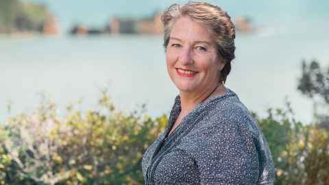 Linda Tyler portrait photo on hill with sea as backdrop