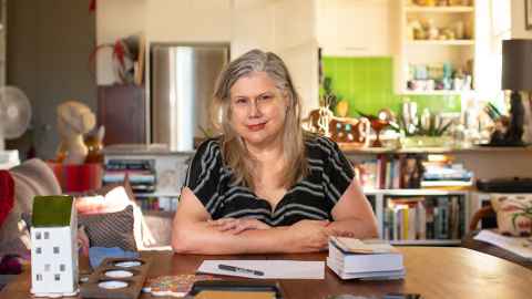 Associate Professor Paula Morris at home surrounded by books. Her new anthology is out on 10 August.