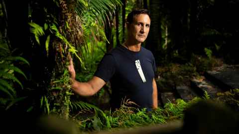 Dan Hikuroa standing amongst native New Zealand greenery.