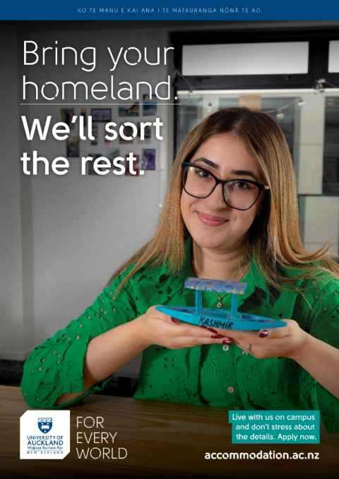 Maryam sits at her kitchen table smiling and holding her shikara in her hands. It is blue and says Kashmir on it. Text reads "Bring your homeland. We'll sort the rest. Live with us on campus and don't stress about the details. Apply now."