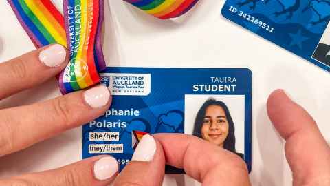hands placing pronoun stickers on a campus card