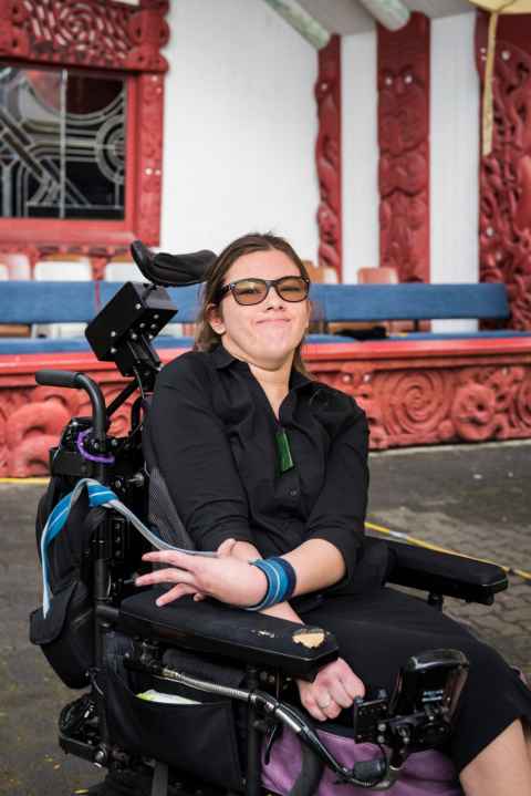 Alicia is in front of the Marae and smiling. 