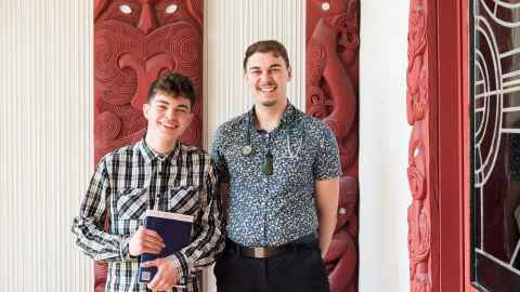 Two Maori students who are brothers, one with textbooks and one with stereoscope.