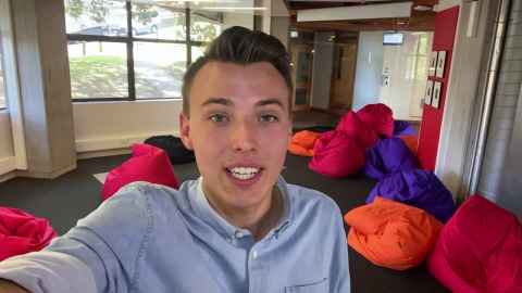 Student taking a selfie in front of beanbags 