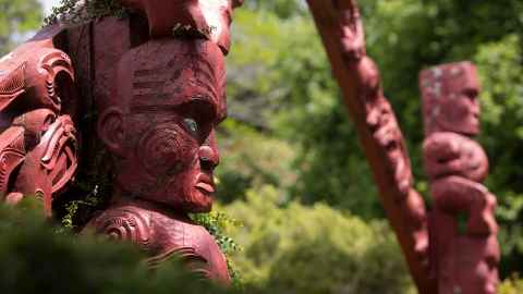 Maori carvings set against trees
